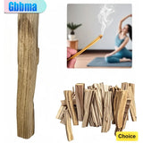 Wooden incense sticks with a match and a blurred background of a person meditating.