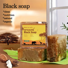 African Black Soap Acne Treatment bar on green leaf with blurred natural background showing handmade quality.