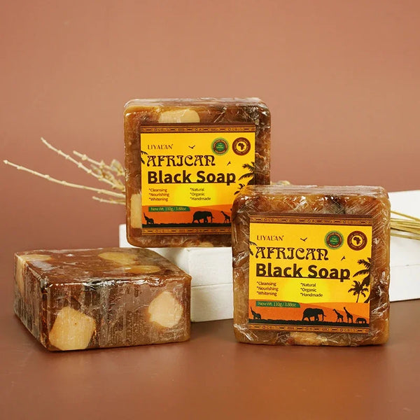 African Black Soap with Organic Shea Butter three bars with packaging on brown background for natural skin care.