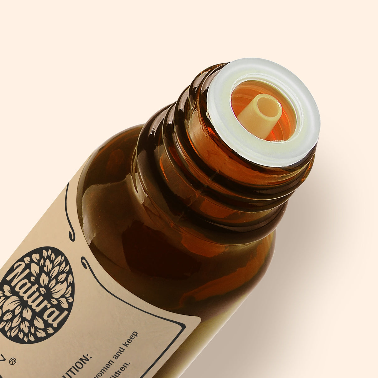 Close-up of a brown glass bottle with a white cap on a beige background