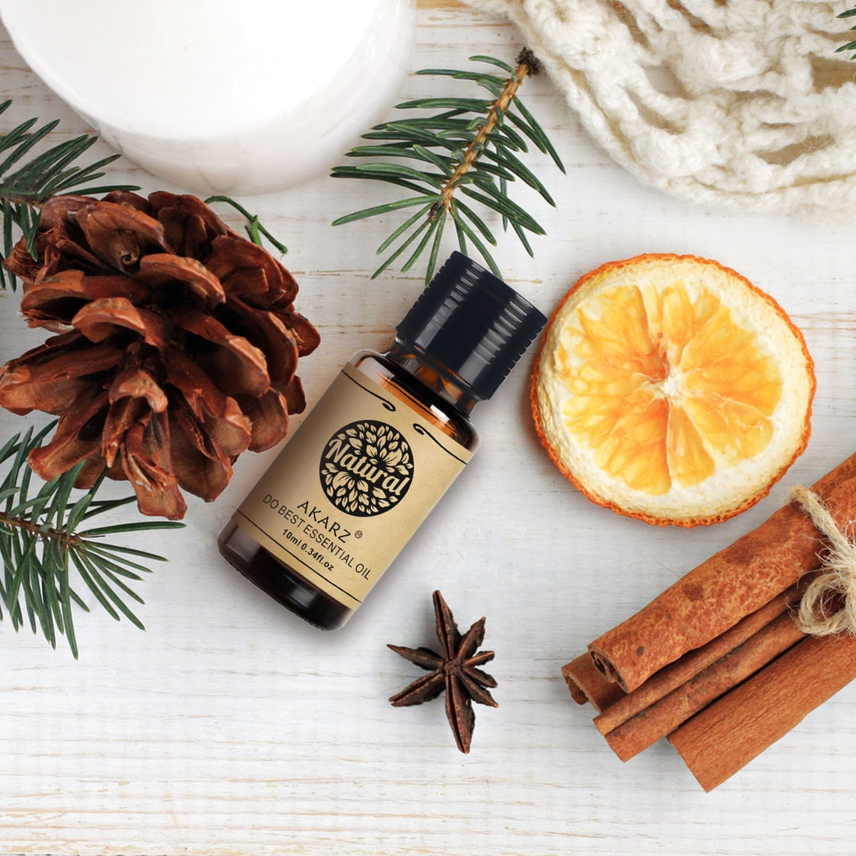 Bottle of Natural Akarz Pure Essential Oil with Christmas-themed elements on a white surface