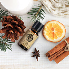 Bottle of Natural Akarz Pure Essential Oil with Christmas-themed elements on a white surface