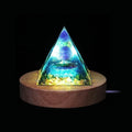 Amethyst Orgone Energy Pyramid glowing on wooden LED base for meditation and healing.