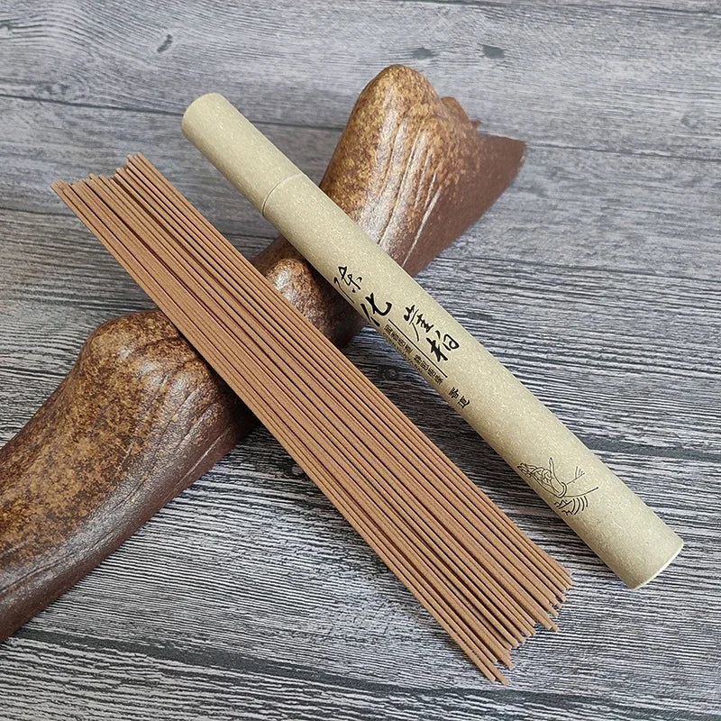 Unopened package of brown incense with a wooden holder on a gray wooden surface