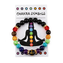 Chakra bracelet with colored beads on a card with chakra symbols and meanings.