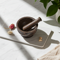 Dark Natural mortar and pestle stone grinder for crushing herbs, spices, and kitchen ingredients.
