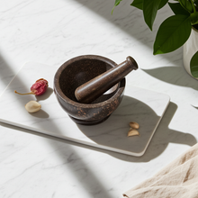 Dark Natural mortar and pestle stone grinder for crushing herbs, spices, and kitchen ingredients.
