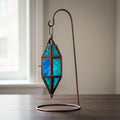 Glass and metal lantern in a chapel shape with aquamarine and blue glass panels