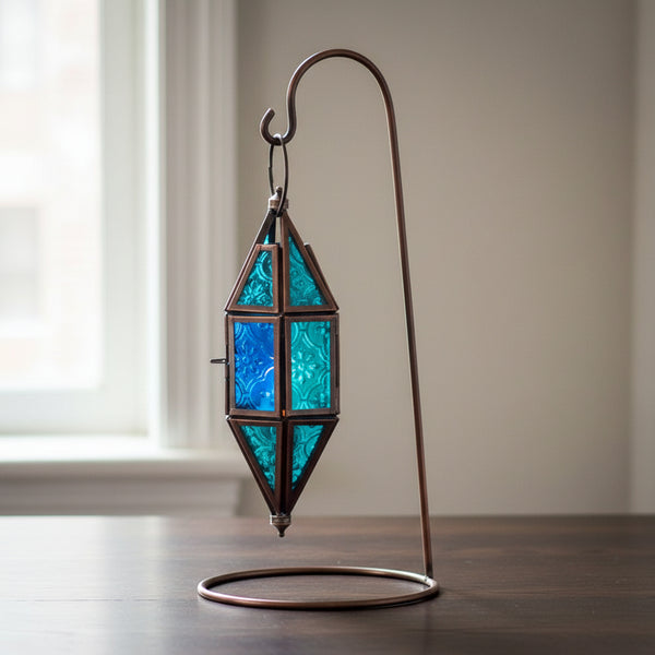 Glass and metal lantern in a chapel shape with aquamarine and blue glass panels
