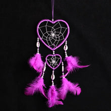 Handmade pink and purple dreamcatcher with feather tassels for home decor, gift giving, and calming room decoration.