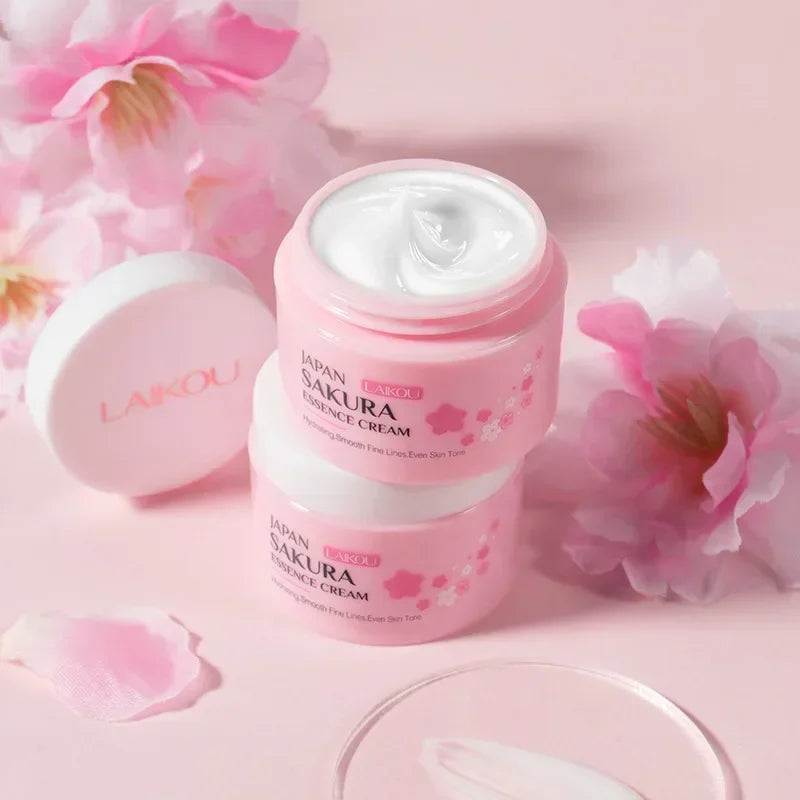 LAIKOU Sakura Face Cream pink jar surrounded by cherry blossom flowers on pink background.