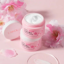 LAIKOU Sakura Face Cream pink jar surrounded by cherry blossom flowers on pink background.