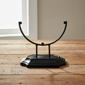 Metal stand for glass suncatchers displayed at an angle, tabletop display base for hanging glass art.