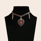 Peach heart cross sword gothic choker necklace for Y2K-inspired looks, streetwear styling, and layered accessory fashion.