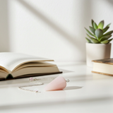 Rose quartz pendulum displayed in a lifestyle setting for dowsing and divination practice.