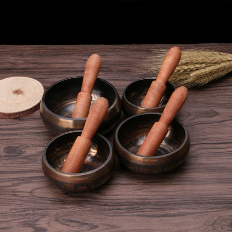 Sacred Chakra Tibetan singing bowl kit with metal bowl, wooden mallet, and cushion for meditation, relaxation, and spiritual wellness use.