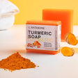 SAUVASINE Turmeric Handmade Soap for dark spots with turmeric root and powder on white background.