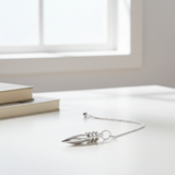 Silver plated pendulum displayed in a lifestyle setting for dowsing and divination practice.