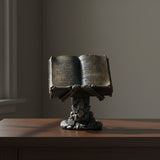 Skeleton holding spell book figurine front view for gothic home decor, altar display, and Halloween styling.
