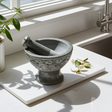 Soapstone mortar and pestle carved with leaves in natural stone for grinding herbs, spices, and seasoning blends.