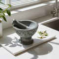 Soapstone mortar and pestle carved with leaves in natural stone for grinding herbs, spices, and seasoning blends.