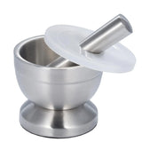 Stainless steel grinding bowl with pestle and lid for crushing herbs, spices, and dry ingredients in the kitchen.