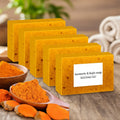 Turmeric Kojic Acid Brightening Soap bars with natural turmeric powder and roots on white background.