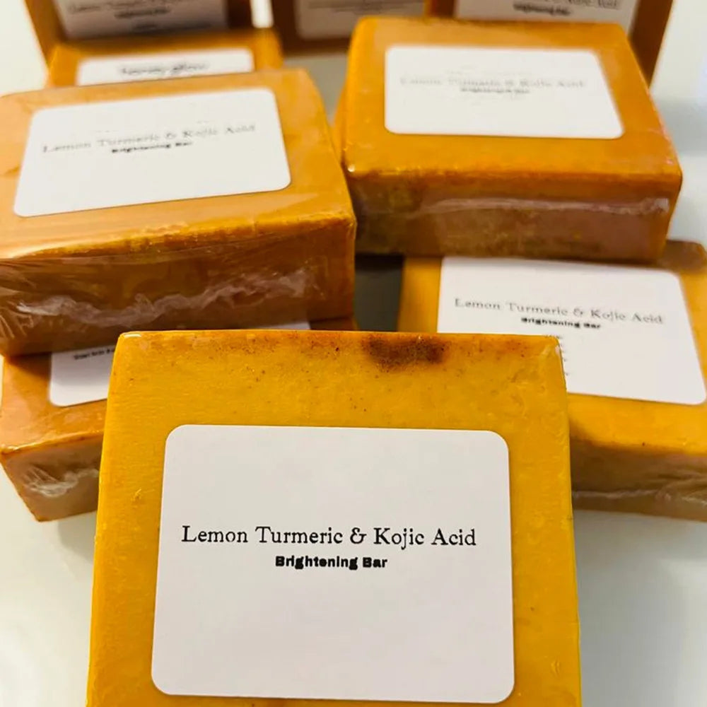 Turmeric Lemon Kojic Acid Soap bars with labels displayed on a white surface.