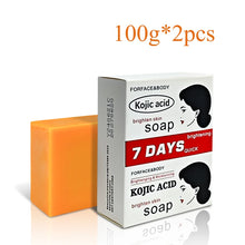 Turmeric Kojic Acid Whitening Soap orange bar next to packaging for natural skin brightening.