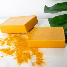Turmeric Kojic Acid Brightening Soap two bars with green leaf on white background.