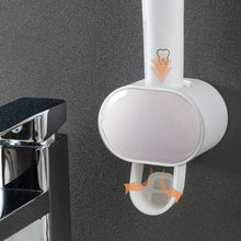 Automatic Toothpaste Dispenser with toothbrush holder slots for organized bathroom storage.