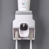 Wall Mount Automatic Toothpaste Dispenser with three toothbrush slots and anti-drip dispenser mechanism.